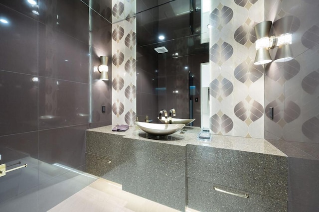 bathroom featuring tile walls and sink