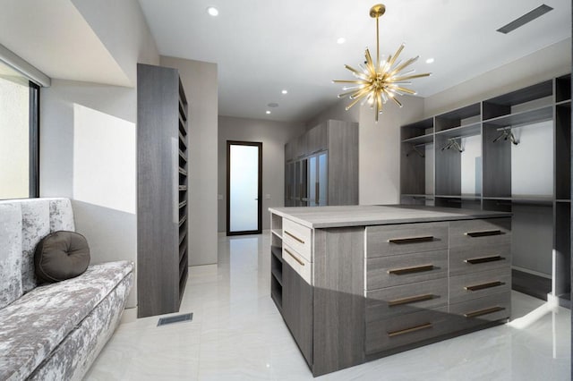 spacious closet with an inviting chandelier