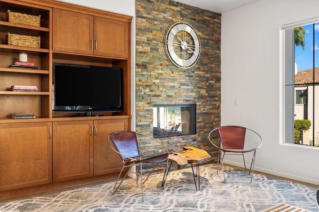 living area featuring a stone fireplace and light tile patterned flooring