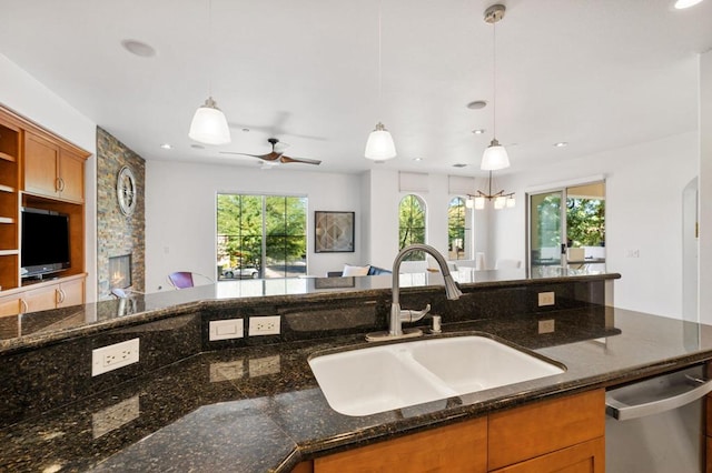 kitchen with dark stone countertops, sink, and pendant lighting