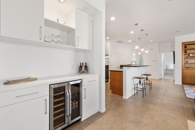 bar with white cabinetry, pendant lighting, light tile patterned floors, and beverage cooler