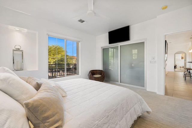 tiled bedroom featuring ceiling fan