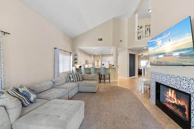 tiled living room featuring a fireplace and high vaulted ceiling