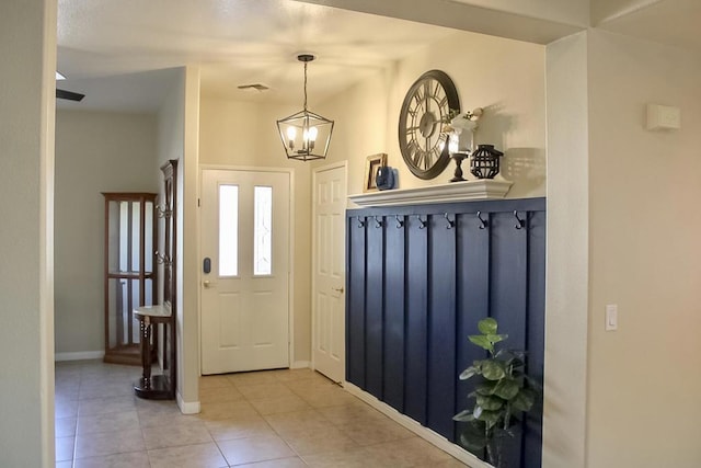 mudroom featuring light tile patterned floors and a notable chandelier