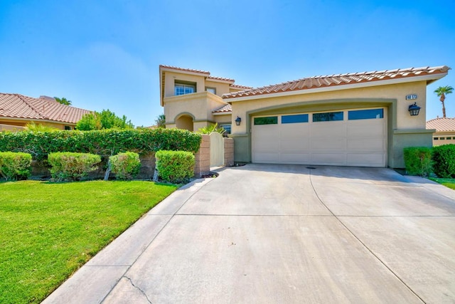 mediterranean / spanish-style house with a garage and a front lawn