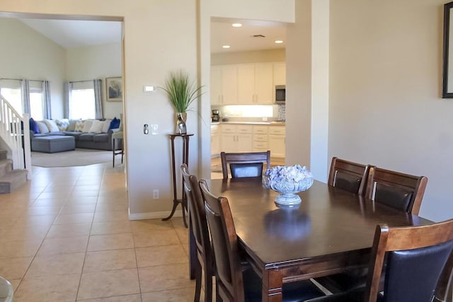 tiled dining space with vaulted ceiling