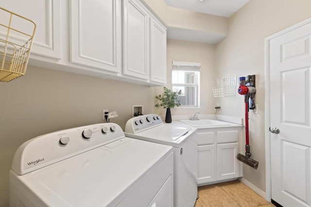 laundry area with cabinets, light tile patterned floors, washer and clothes dryer, and sink