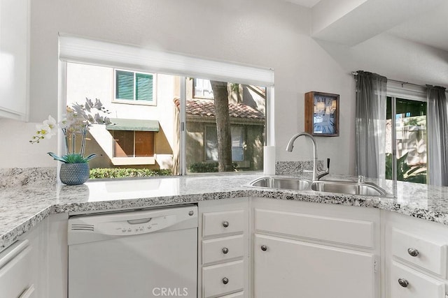 kitchen with light stone countertops, dishwasher, white cabinets, and sink