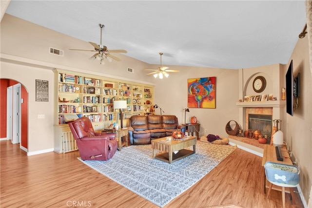 living room featuring ceiling fan, wood-type flooring, and vaulted ceiling