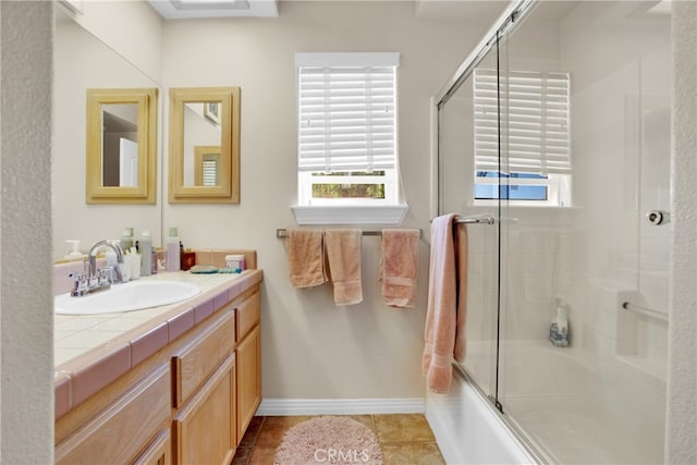 bathroom with vanity, combined bath / shower with glass door, and tile patterned flooring