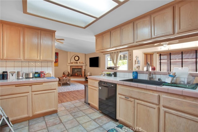 kitchen with dishwasher, decorative backsplash, tile counters, light hardwood / wood-style flooring, and sink