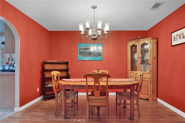 dining space featuring light hardwood / wood-style floors and an inviting chandelier