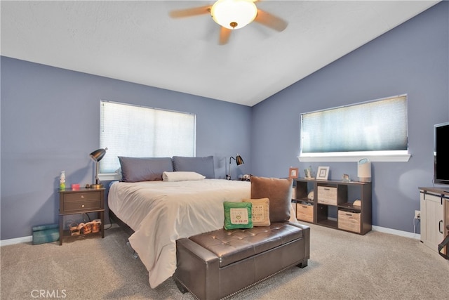 bedroom featuring vaulted ceiling, light carpet, multiple windows, and ceiling fan