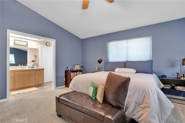 bedroom with light carpet, lofted ceiling, ceiling fan, ensuite bath, and sink