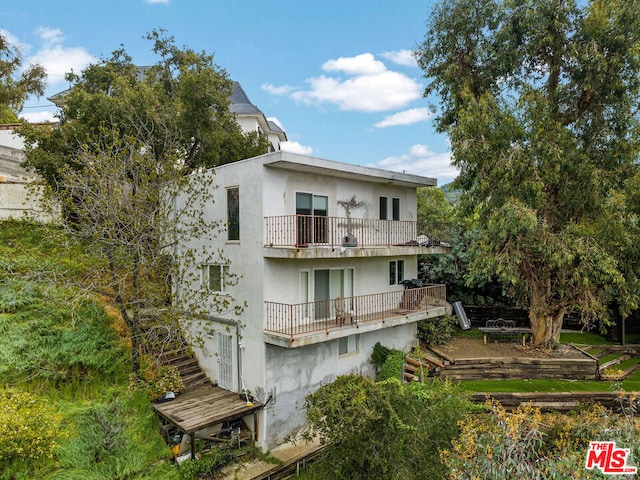 back of property featuring a balcony