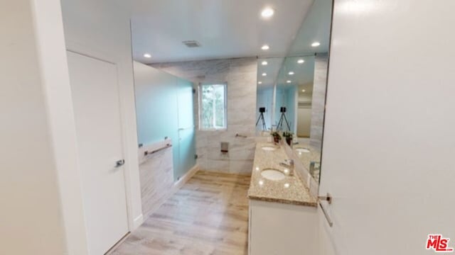 bathroom featuring a shower, vanity, and wood-type flooring