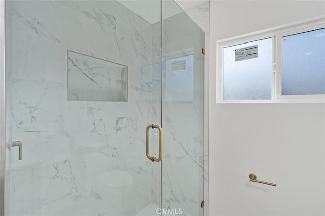 bathroom featuring an enclosed shower and a healthy amount of sunlight