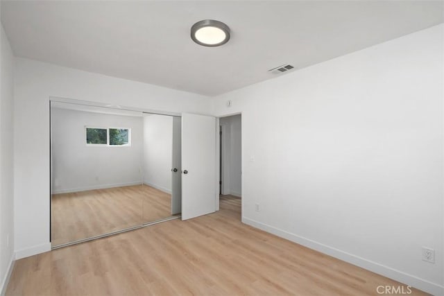 unfurnished bedroom featuring a closet and light hardwood / wood-style floors