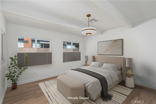 bedroom featuring beamed ceiling and hardwood / wood-style flooring