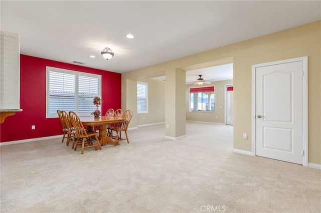 carpeted dining area with ceiling fan and a healthy amount of sunlight