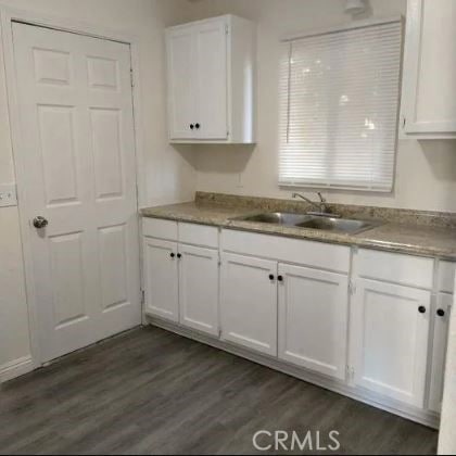 kitchen featuring sink, white cabinetry, and dark hardwood / wood-style flooring