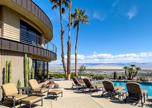 view of patio featuring a mountain view and a balcony