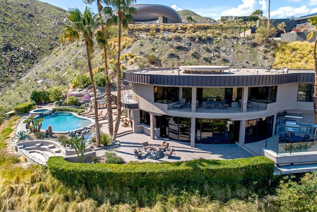 rear view of house featuring a mountain view and a patio