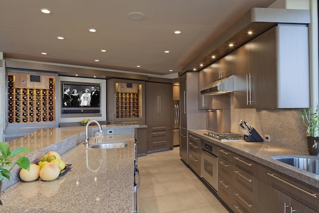 kitchen featuring sink, tasteful backsplash, light stone countertops, and stainless steel appliances