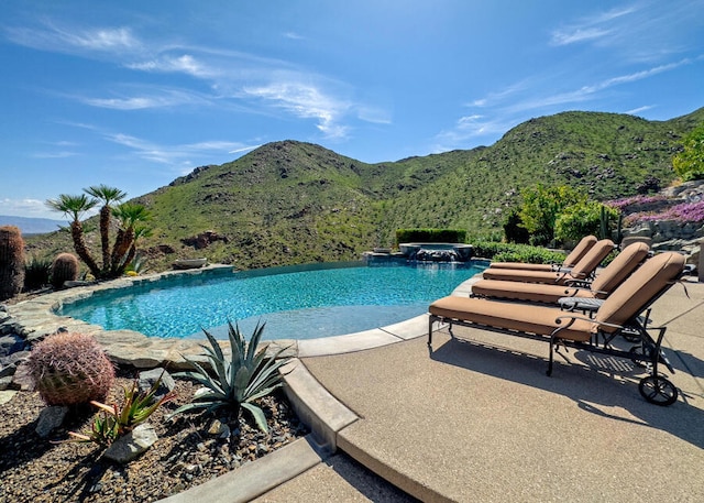 view of swimming pool with an in ground hot tub, a mountain view, and a patio