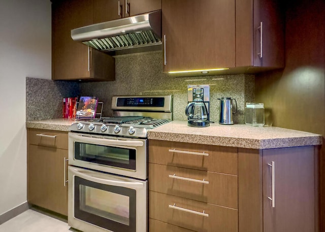 kitchen featuring decorative backsplash, range with two ovens, and extractor fan