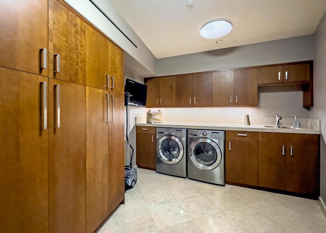 clothes washing area with cabinets, sink, and independent washer and dryer