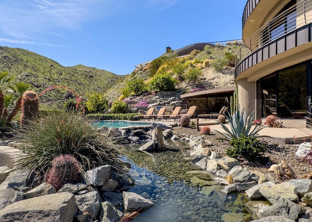 view of pool featuring a mountain view and a patio