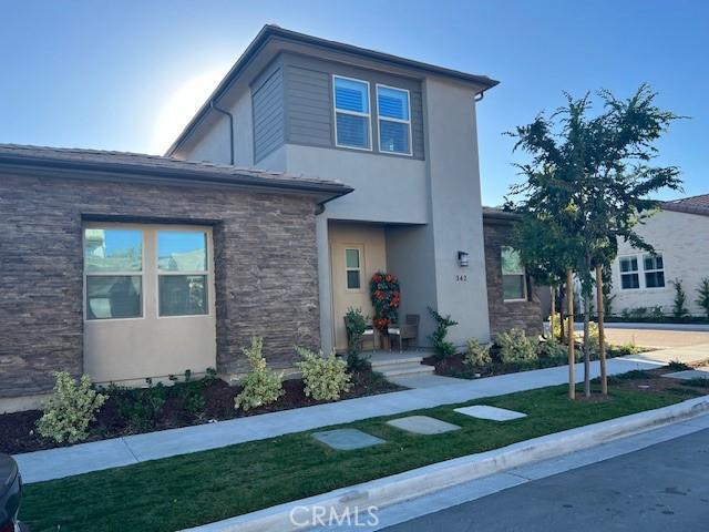 342 Sunrise Rd, Rancho Mission Viejo, CA 92694 - view of front of house featuring stone siding, a front yard, and stucco siding