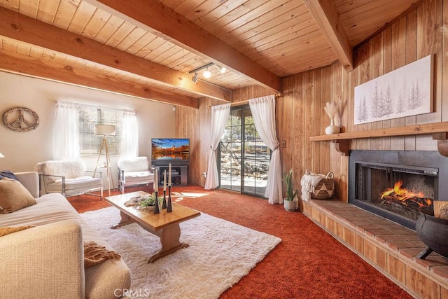 living room featuring beamed ceiling, a brick fireplace, and wood ceiling