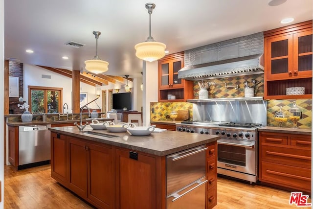 kitchen featuring stainless steel appliances, backsplash, pendant lighting, light hardwood / wood-style floors, and a kitchen island