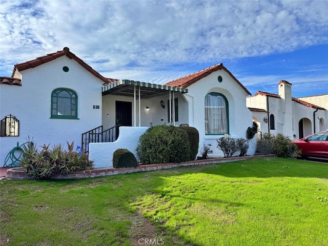 mediterranean / spanish-style home with a front lawn