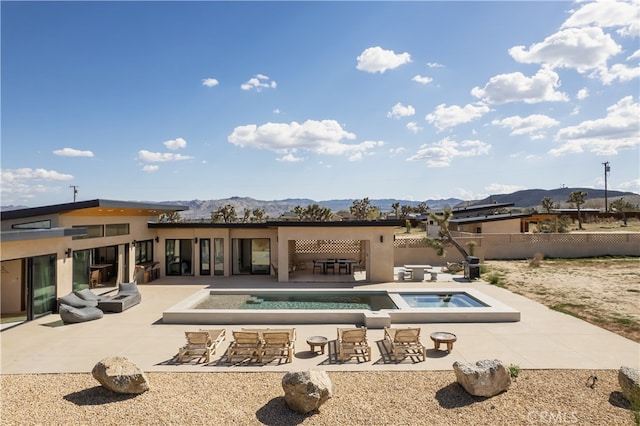 view of swimming pool with an in ground hot tub, a mountain view, and a patio