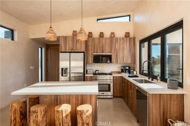 kitchen with sink, stainless steel appliances, vaulted ceiling, and a healthy amount of sunlight