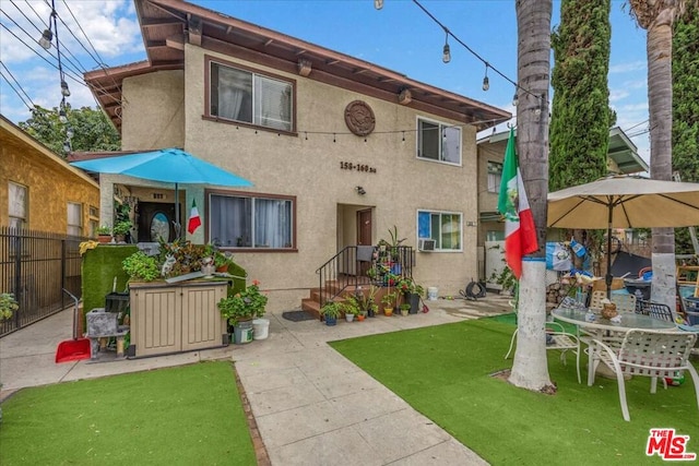 back of house featuring a patio and a yard