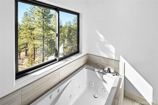 bathroom with plenty of natural light and tiled tub