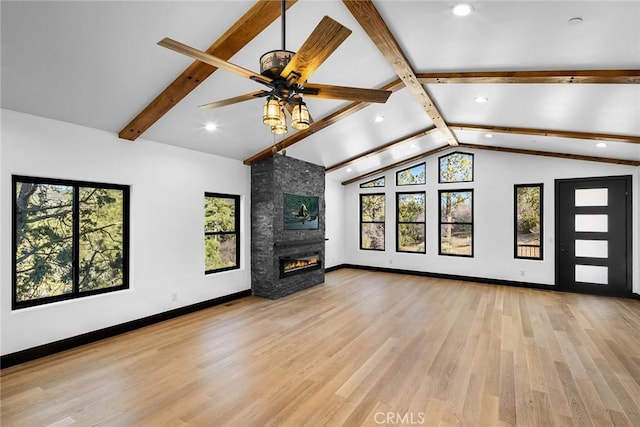 unfurnished living room with lofted ceiling with beams, light hardwood / wood-style floors, a fireplace, and ceiling fan