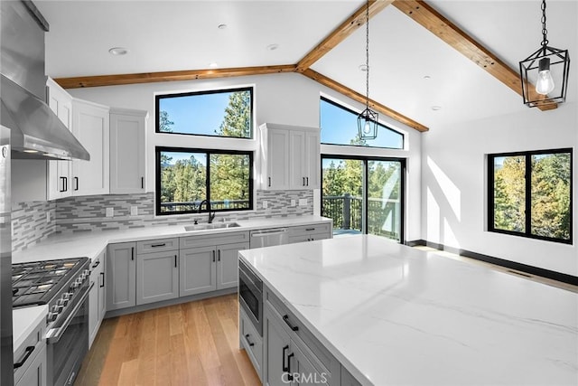 kitchen featuring beam ceiling, tasteful backsplash, and stainless steel appliances