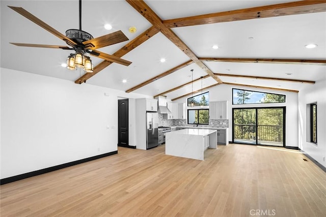 kitchen featuring pendant lighting, white cabinets, light wood-type flooring, a kitchen island, and stainless steel appliances