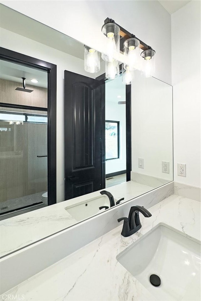 bathroom featuring plenty of natural light, toilet, a shower, and vanity