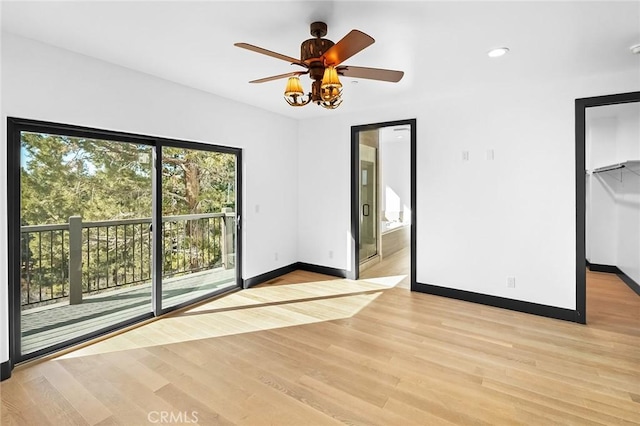 unfurnished bedroom featuring access to exterior, light wood-type flooring, ensuite bathroom, ceiling fan, and a closet