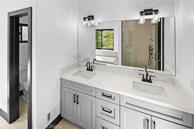 full bathroom featuring wood-type flooring, vanity, toilet, and independent shower and bath