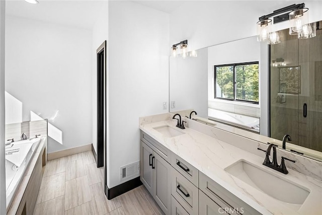 bathroom with shower with separate bathtub and vanity