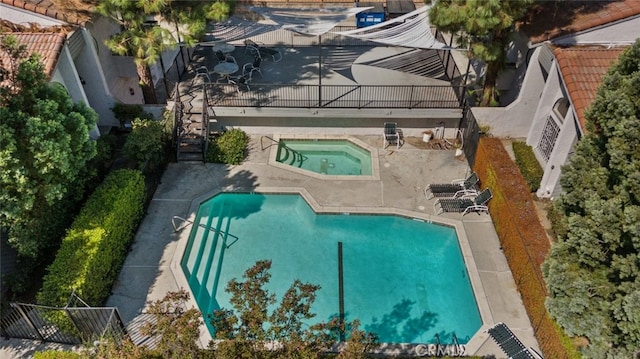 view of swimming pool featuring a community hot tub and a patio area