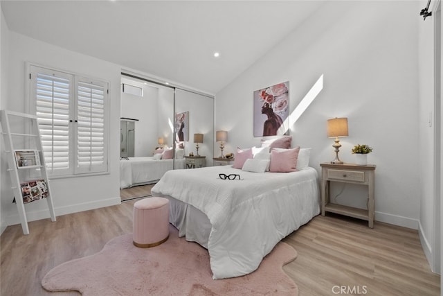 bedroom with a closet, lofted ceiling, and light wood-type flooring