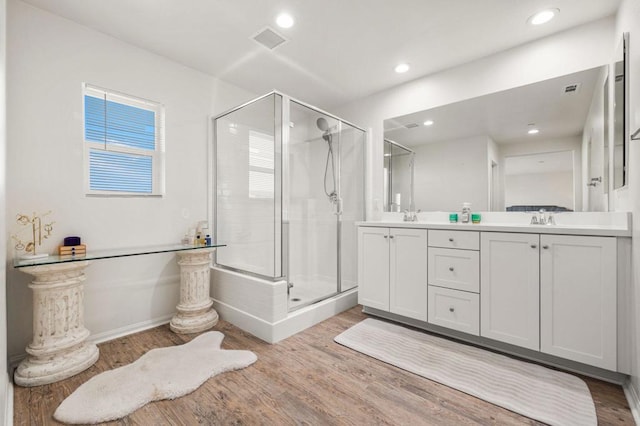 bathroom featuring vanity, hardwood / wood-style flooring, and a shower with shower door